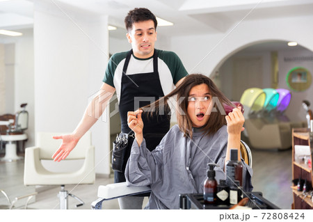 Displeased woman after haircut having conflict hairdresser 72808424