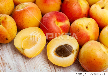 Fresh apricots whole and halves on wooden table 72808751