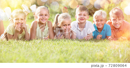 kids lying on green grass 72809064