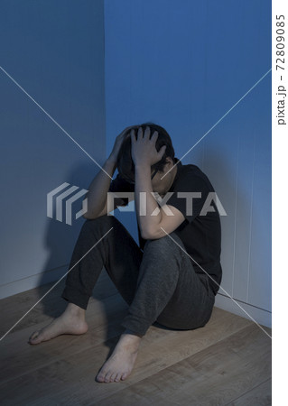 暗い部屋で床に座っている男性 暗い部屋で床に座っている男性 72809085