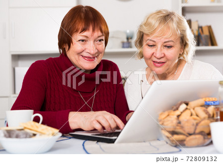 Smiling pensioners females with laptop Smiling pensioners females with laptop 72809132