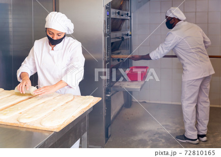 Female baker prepares delicious dough coca bread at bakery Female baker prepares delicious dough coca bread at bakery 72810165