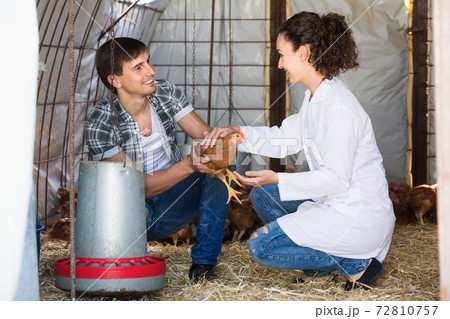 Female veterinarian in uniform talking to farmer 72810757