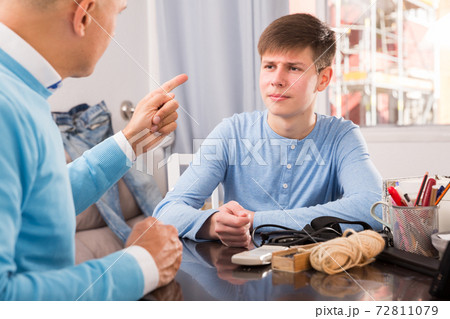 Teenager listening to reprimanding father Teenager listening to reprimanding father 72811079