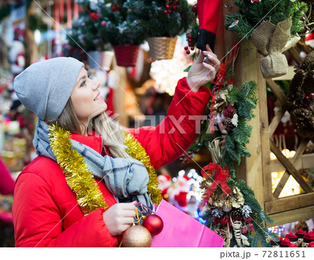 Positive female with handmade Christmas gifts on the street market Positive female with handmade Christmas gifts on the street market 72811651