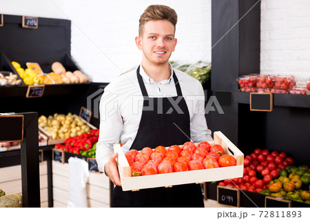 Man seller moving box of persimmons 72811893