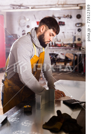 Young man engineer calculation size of material Young man engineer calculation size of material 72812369