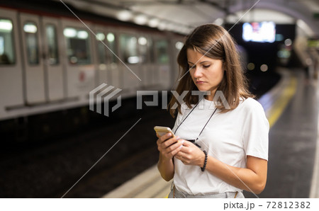 Female using mobile phone on station Female using mobile phone on station 72812382