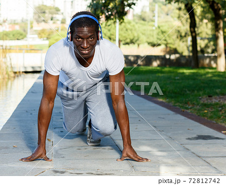Athletic african american man starting running in park outdoor Athletic african american man starting running in park outdoor 72812742