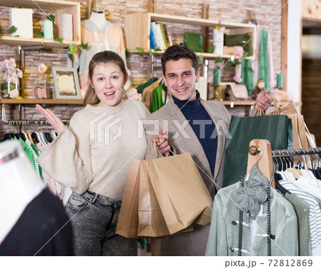 Smiling couple is satisfied of purchases and standing with package Smiling couple is satisfied of purchases and standing with package 72812869