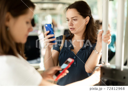 Brunette with smartphone in bus Brunette with smartphone in bus 72812968