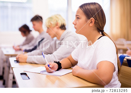 Teen girl sitting at desk in classroom Teen girl sitting at desk in classroom 72813295