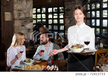 Waitress inviting guests for lunch 72813753