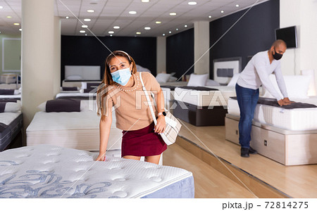 Nice couple in masks choosing mattress Nice couple in masks choosing mattress 72814275