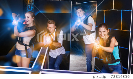 First person view of young people aiming from laser gun in dark First person view of young people aiming from laser gun in dark 72814356