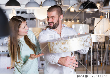 Young family touching floor lamp in the furniture store Young family touching floor lamp in the furniture store 72814578