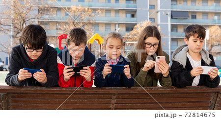 Group of children communicate using smartphones in the playground 72814675