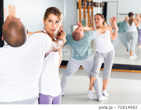 Strong cheerful woman is training with man on the self-defense course 72814682