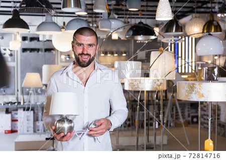 Portrait of man choosing bedside lamp in showroom Portrait of man choosing bedside lamp in showroom 72814716