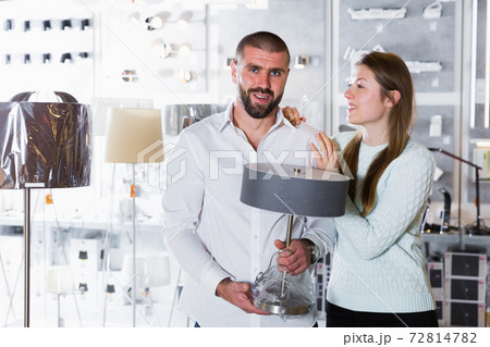 Portrait of family couple choosing floor lamp in shop 72814782