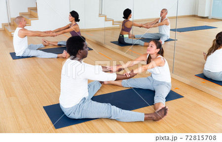 Couples practicing yoga with partner at studio 72815708