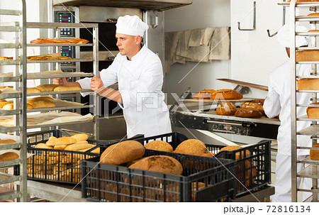 Man transporting cart with bread in bakery 72816134