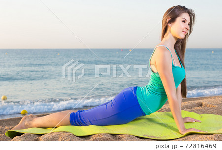 Woman in blue T-shirt is practicing stretching Woman in blue T-shirt is practicing stretching 72816469