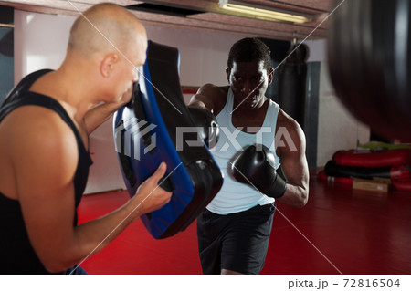 Men practicing effective techniques of self-defence during individual class in training room Men practicing effective techniques of self-defence during individual class in training room 72816504