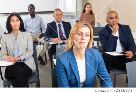 Young business woman sitting in conference hall at business event Young business woman sitting in conference hall at business event 72816678