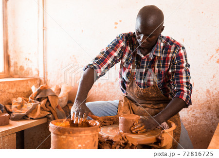 Man making ceramics on pottery wheel 72816725
