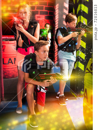 Girls and boys playing laser tag Girls and boys playing laser tag 72816813