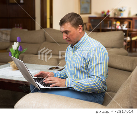 Man using laptop during filling out papers 72817014