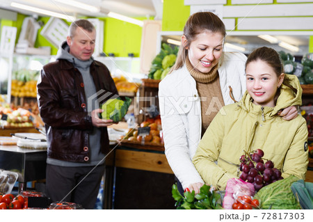 Smiling woman and child choosing for fresh delicious fruits Smiling woman and child choosing for fresh delicious fruits 72817303