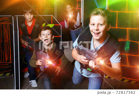 Portrait of preteen boy with laser gun having fun on dark lasert Portrait of preteen boy with laser gun having fun on dark lasert 72817562