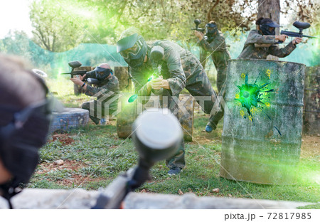 Female paintball player aiming in shootout 72817985