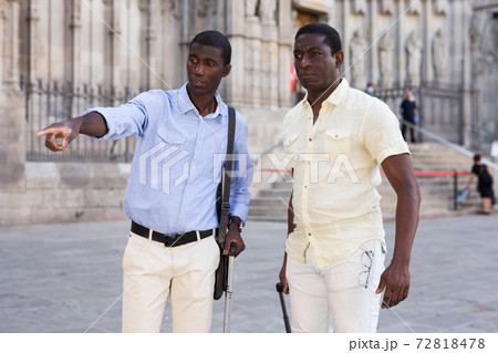 Positive african american men talking and pointing finger at the street 72818478