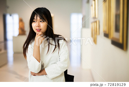 Chinese woman near picture collection in museum 72819129