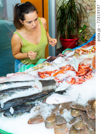 Woman choosing seafood at fish shop 72819597