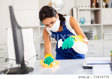Kazhahstani woman wearing uniform ana mask cleaning at office Kazhahstani woman wearing uniform ana mask cleaning at office 72819770
