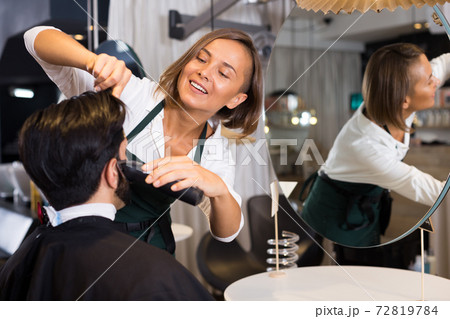 female professional shaving male's hair 72819784