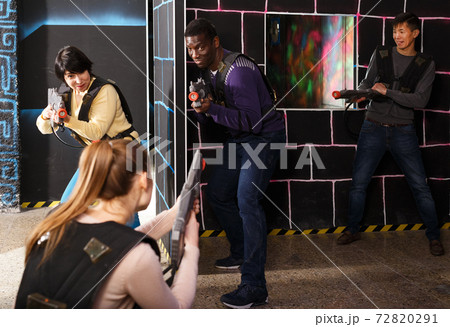 group of adult people with laser guns having fun group of adult people with laser guns having fun 72820291
