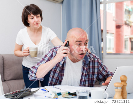 Wife calms husband who is upset about financial results. Wife calms husband who is upset about financial results. 72821311