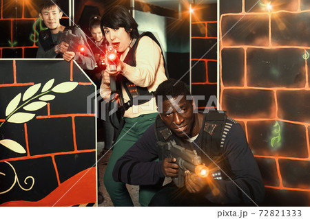 Multiracial couple playing lasertag Multiracial couple playing lasertag 72821333