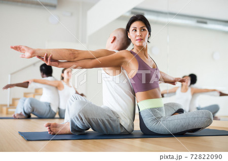 Woman practicing yoga with partner at studio 72822090