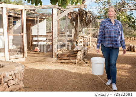 Woman feeding poultry Woman feeding poultry 72822091