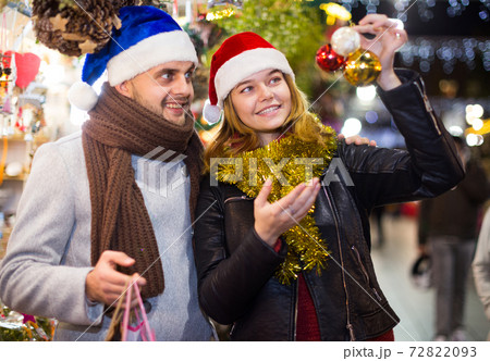 Girl with boy in Christmas hat choosing decorations 72822093