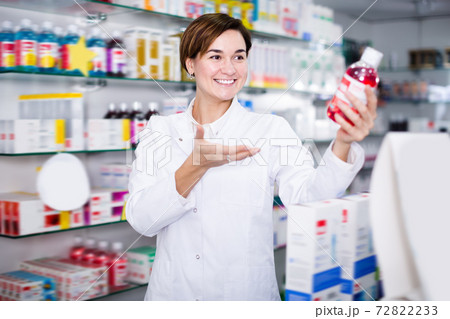 Brunette pharmacist offering reliable medicine Brunette pharmacist offering reliable medicine 72822233