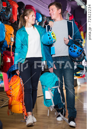 satisfied girl and guy select gear for hiking and camping in sports shop satisfied girl and guy select gear for hiking and camping in sports shop 72822234