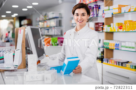 Female pharmacist offering help in choosing at counter in pharmacy 72822311