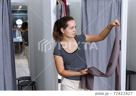 Woman trying clothes in fitting room 72822827